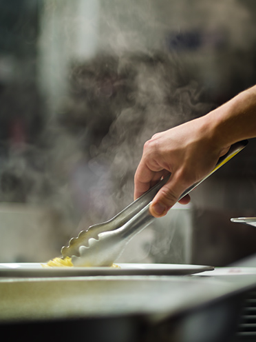 # ulisse albiati food photographer: a genuine restaurant staff, a sous-chef de cuisine is really cooking. Il Gambero Pazzo restaurant in Lastra a Signa, Tuscany.