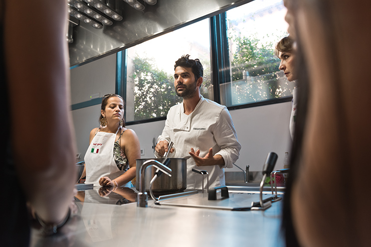 # ulisse albiati food photographer: a master chef teaches a new flavorful recipe during a cooking workshop. Cooking school in Florence, Tuscany.