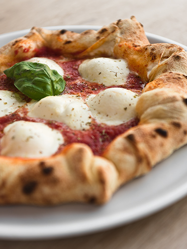 # ulisse albiati food photographer: a tasty pizza margherita with filled crust as complete meal. Le Pavoniere restaurant in Florence, Tuscany.