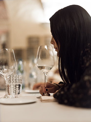 # ulisse albiati food photographer: a customer with a glass. Osteria di Passignano restaurant in Tavarnelle Val di Pesa, Tuscany.