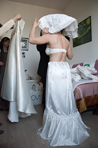 # The wedding dressing of the white bride. The bridal gown with a great help from the godparents. A candid shot.