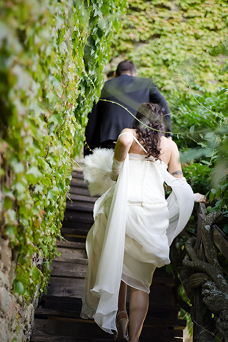 # The couple goes up on the old ladder made of wood. Green around (Castello di Romena, Casentino, Tuscany).