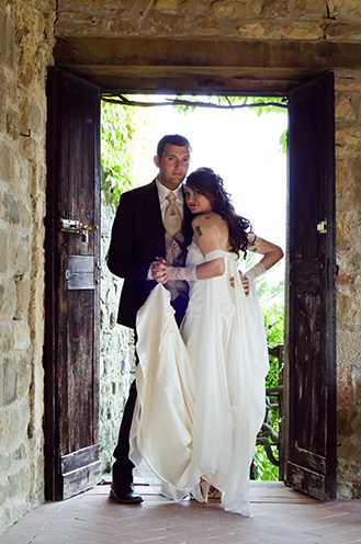 # A romantic embrace, just like two dancers in the evening. The frame of an old door on the background (Castello di Romena, Casentino, Tuscany).