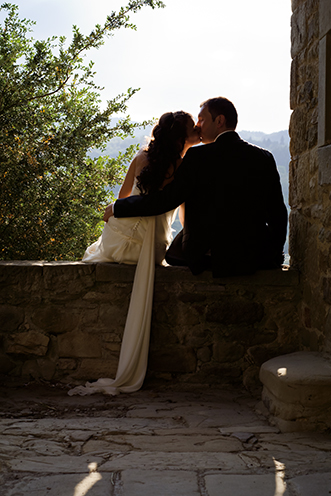 # A kiss during the last light of the day. Silhouette under the lodge of the chapel (Castello di Romena, Casentino, Tuscany).