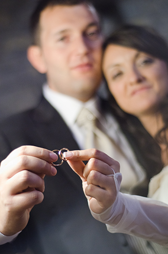 # The bridegroom and the bride show their own wedding rings. Two beautiful smiles.